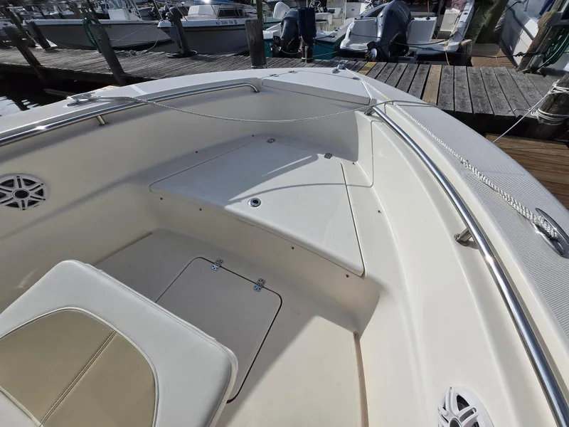 Slide: The Image of 2021 Bulls Bay 200 CC boat interior with seating and storage, docked at a marina. - 24