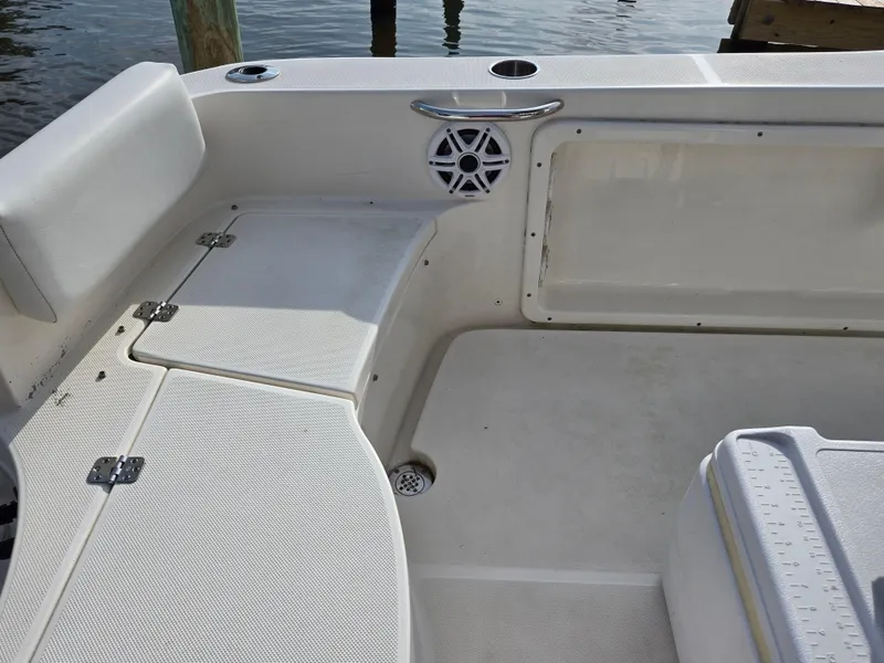 Slide: The Image of 2021 Bulls Bay 200 CC boat interior with seating and speaker, docked by the water. - 36