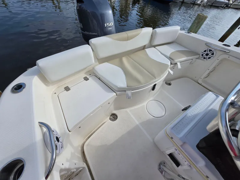 Slide: The Image of 2021 Bulls Bay 200 CC boat interior with seating and motor, docked by the water. - 44