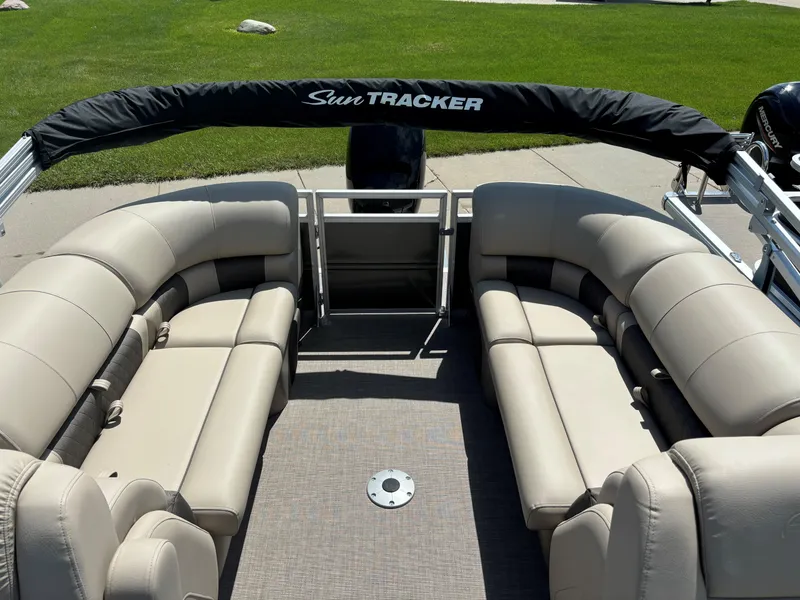 Slide: The Image of 2024 Sun Tracker Party Barge 24 DLX interior with beige seating and black canopy. - 6