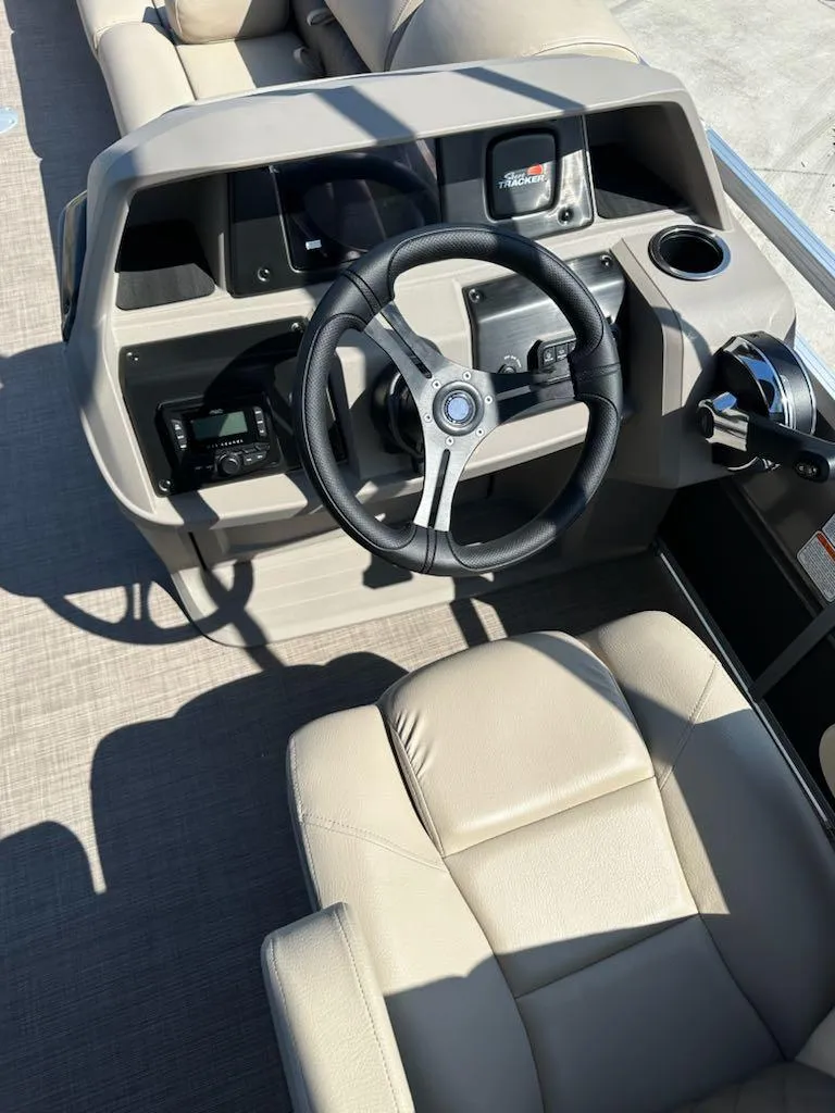 Slide: The Image of 2024 Sun Tracker Party Barge 24 DLX helm with steering wheel and control panel. - 4
