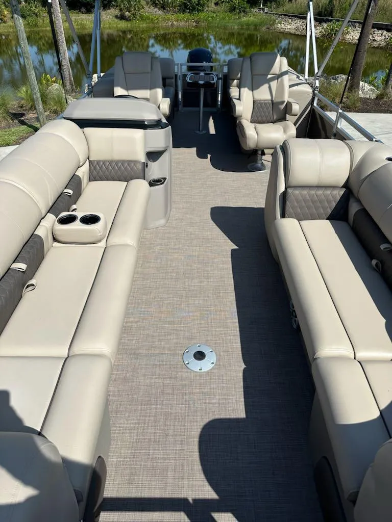 Slide: The Image of 2024 Sun Tracker Party Barge 24 DLX interior with beige seating and spacious layout. - 5
