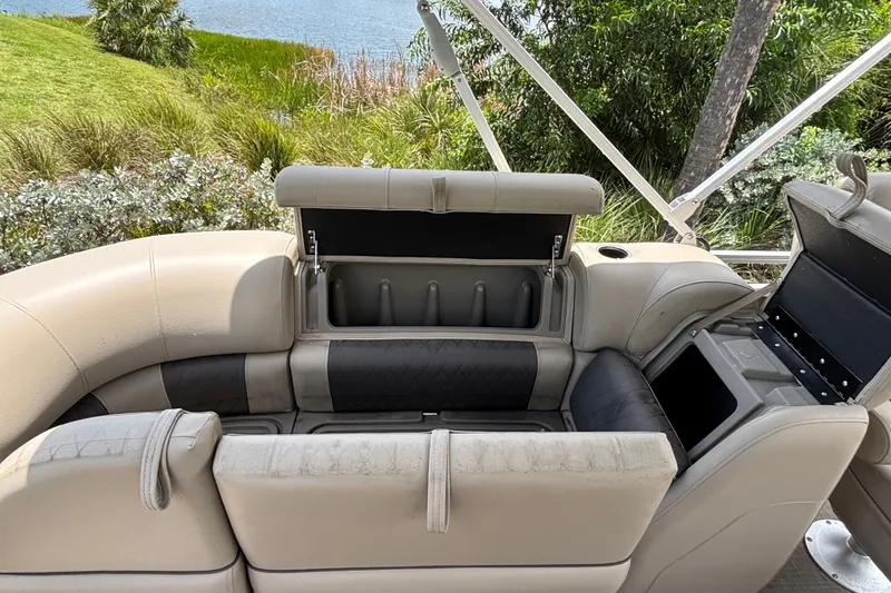 Slide: The Image of 2024 Sun Tracker Party Barge 24 DLX interior seating with storage compartments open. - 14