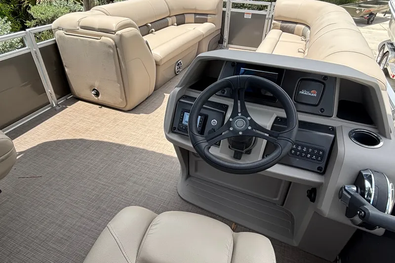 Slide: The Image of 2024 Sun Tracker Party Barge 24 DLX interior with steering console and plush seating. - 13