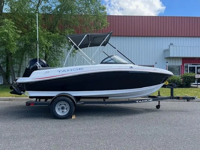 The Image of 2024 Tahoe 185 S boat on trailer, black and white exterior, parked outdoors. - 0