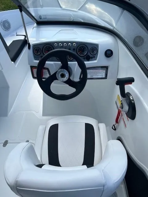 Slide: The Image of 2024 Tahoe 185 S boat cockpit with steering wheel and white captain's chair. - 9