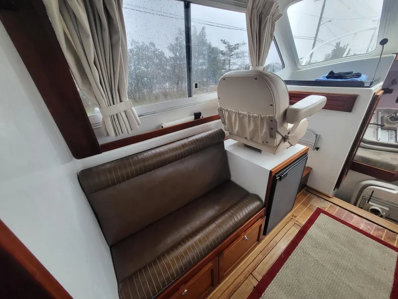 Slide: The Image of 2012 Crusader Boats outboard cruiser interior with seating, helm, and wood accents. - 10