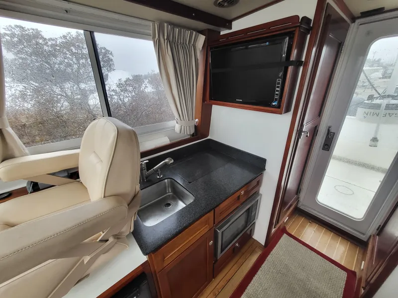 Slide: The Image of 2012 Crusader Boats outboard cruiser interior with kitchenette and seating. - 12