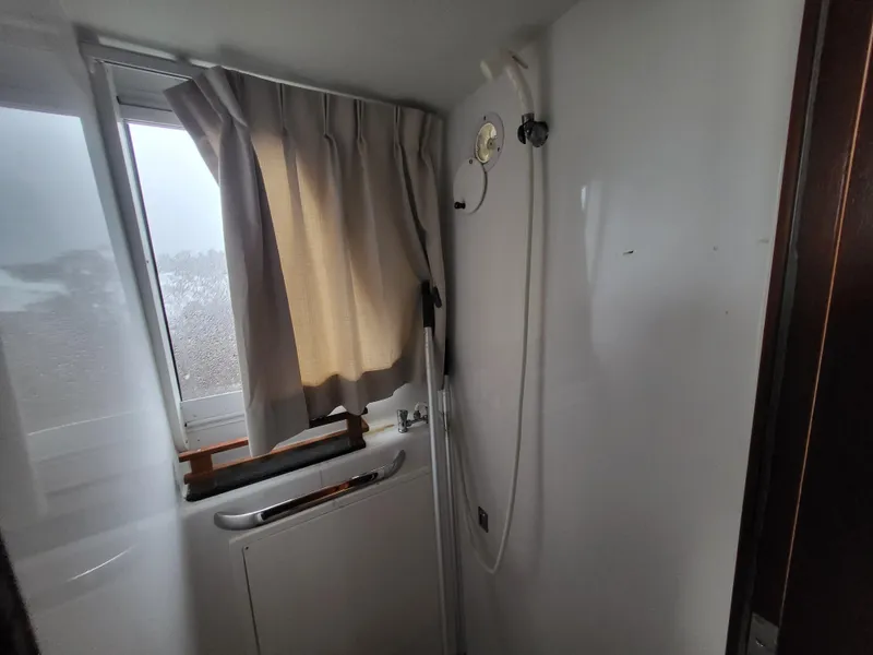 Slide: The Image of Interior of 2012 Crusader Boats outboard cruiser bathroom with shower and window. - 13