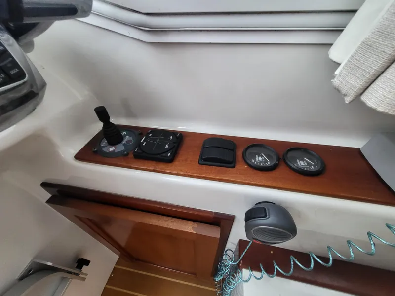 Slide: The Image of Control panel of a 2012 Crusader Boats outboard cruiser with various switches and dials. - 18