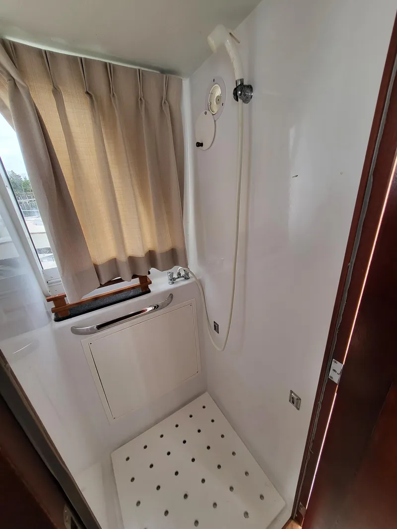 Slide: The Image of Shower area in 2012 Crusader Boats outboard cruiser with curtain and handheld showerhead. - 29