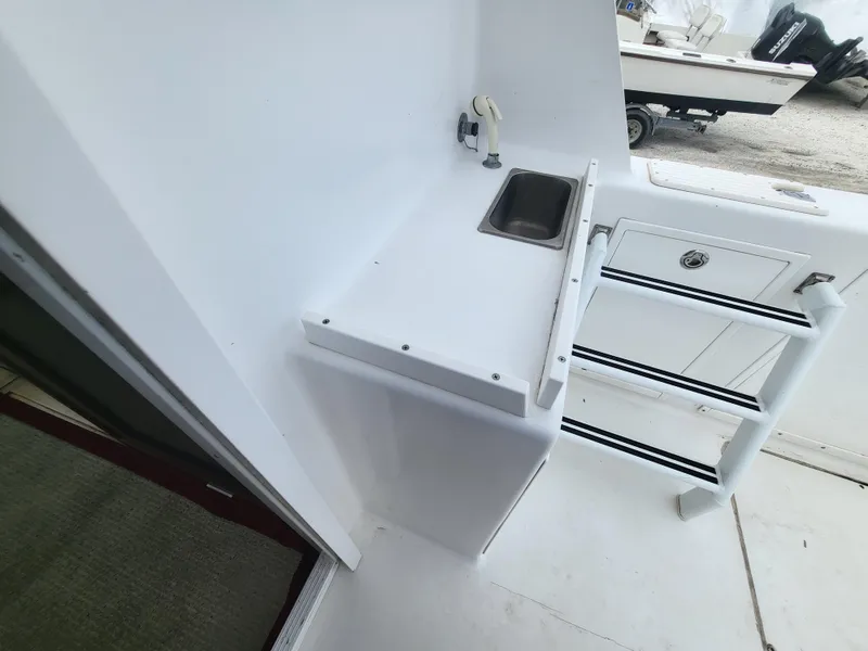 Slide: The Image of 2012 Crusader Boats outboard cruiser interior with sink and storage area. - 32