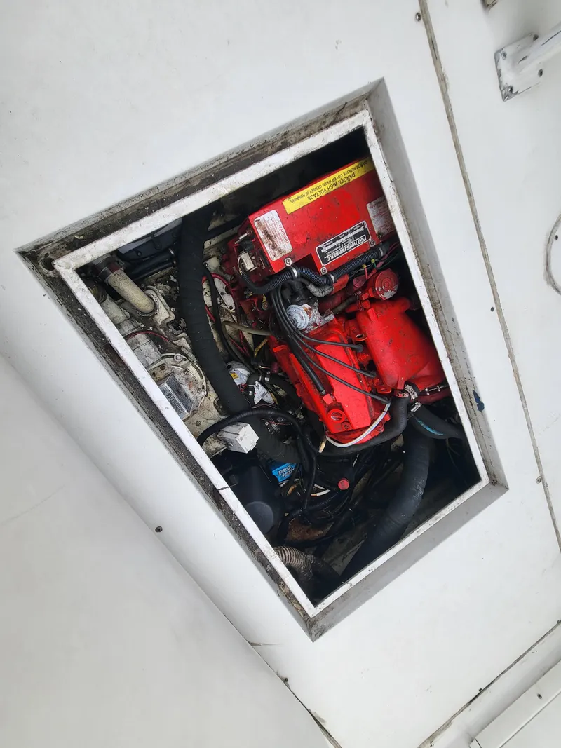 Slide: The Image of Engine compartment of a 2012 Crusader Boats outboard cruiser, showcasing red engine components. - 47