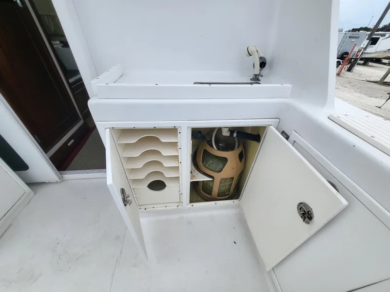 Slide: The Image of 2012 Crusader Boats outboard cruiser with open storage compartments and propane tank. - 48