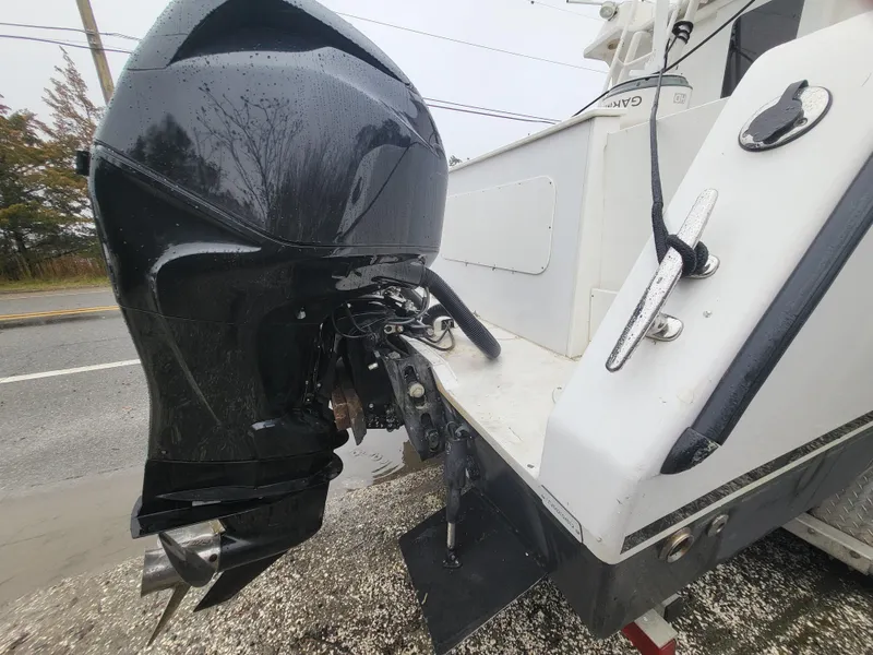 Slide: The Image of 2012 Crusader Boats outboard cruiser with black motor, parked on roadside. - 5