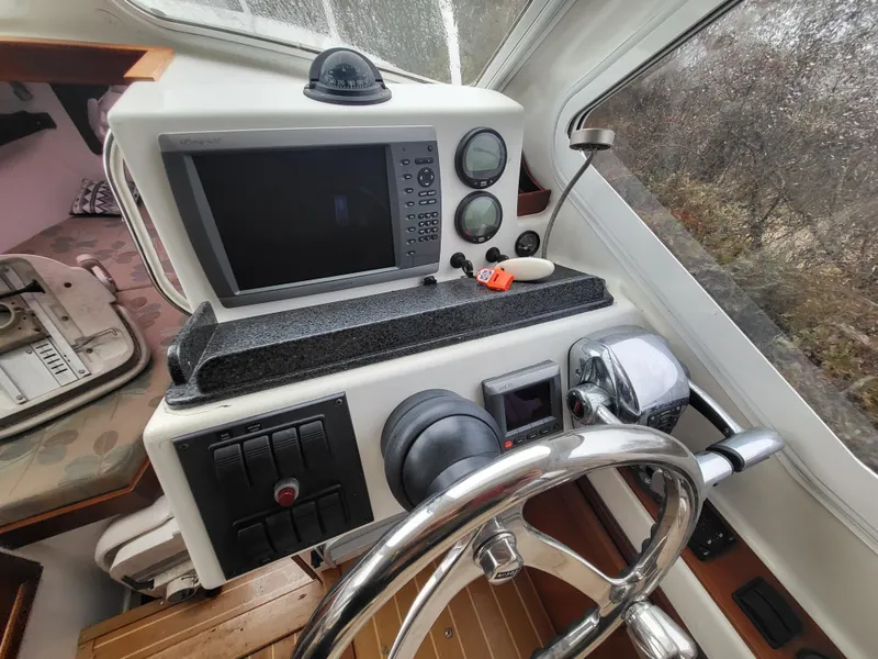 Slide: The Image of Control panel of a 2012 Crusader Boats outboard cruiser with steering wheel and navigation equipment. - 6