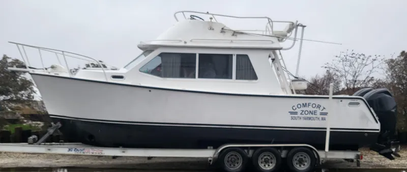Slide: The Image of 2012 Crusader Boats outboard cruiser on trailer, labeled "Comfort Zone," side view. - 8