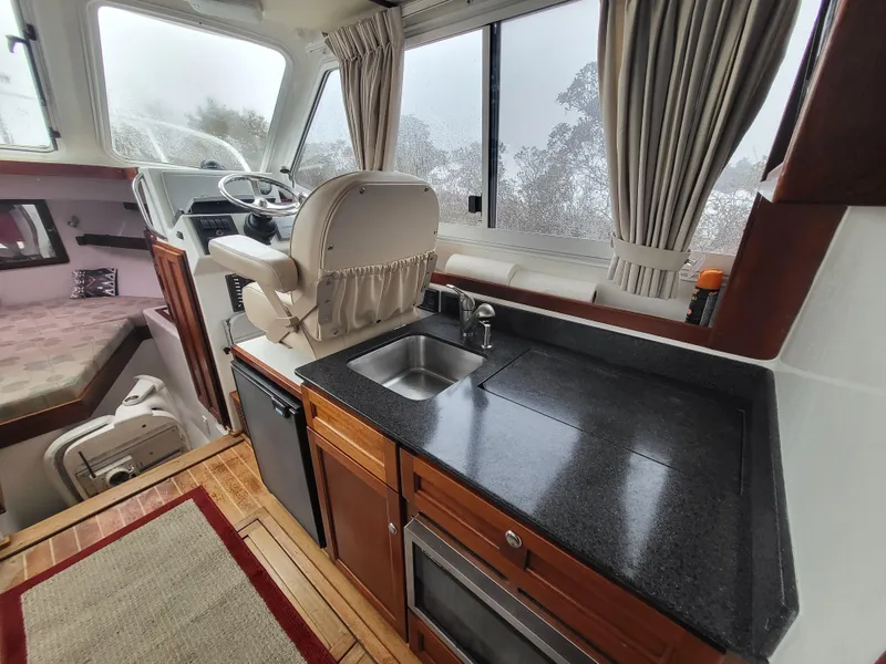Slide: The Image of Interior of 2012 Crusader Boats outboard cruiser with kitchen and helm station. - 9