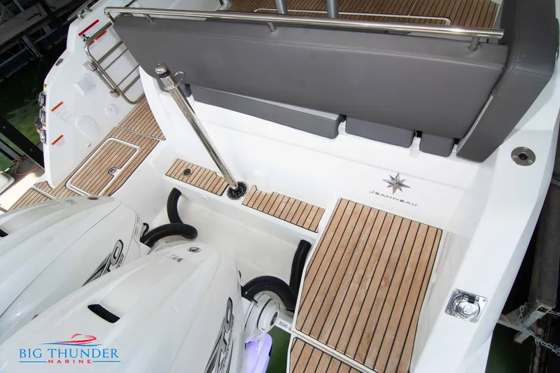 Slide: The Image of 2024 Jeanneau Leader 10.5 WA boat stern with twin engines and teak decking. - 10