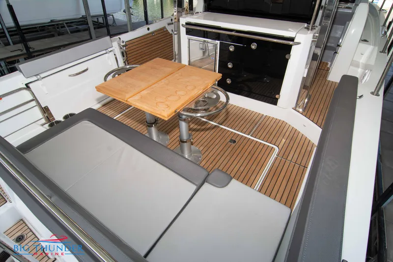 Slide: The Image of 2024 Jeanneau Leader 10.5 WA boat interior with seating and wooden table. - 14