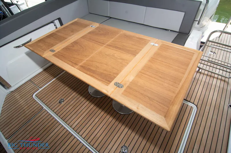 Slide: The Image of 2024 Jeanneau Leader 10.5 WA boat interior with wooden table and seating. - 17
