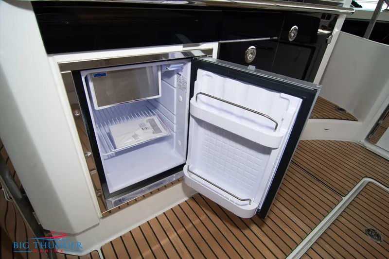 Slide: The Image of Open mini fridge on 2024 Jeanneau Leader 10.5 WA boat with teak flooring. - 26