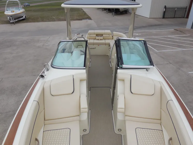 Slide: The Image of 2019 Chris-Craft Launch 28 GT boat interior with beige seating and dual windshields. - 18