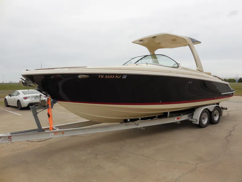 Slide: The Image of 2019 Chris-Craft Launch 28 GT boat on a trailer in a parking lot. - 7
