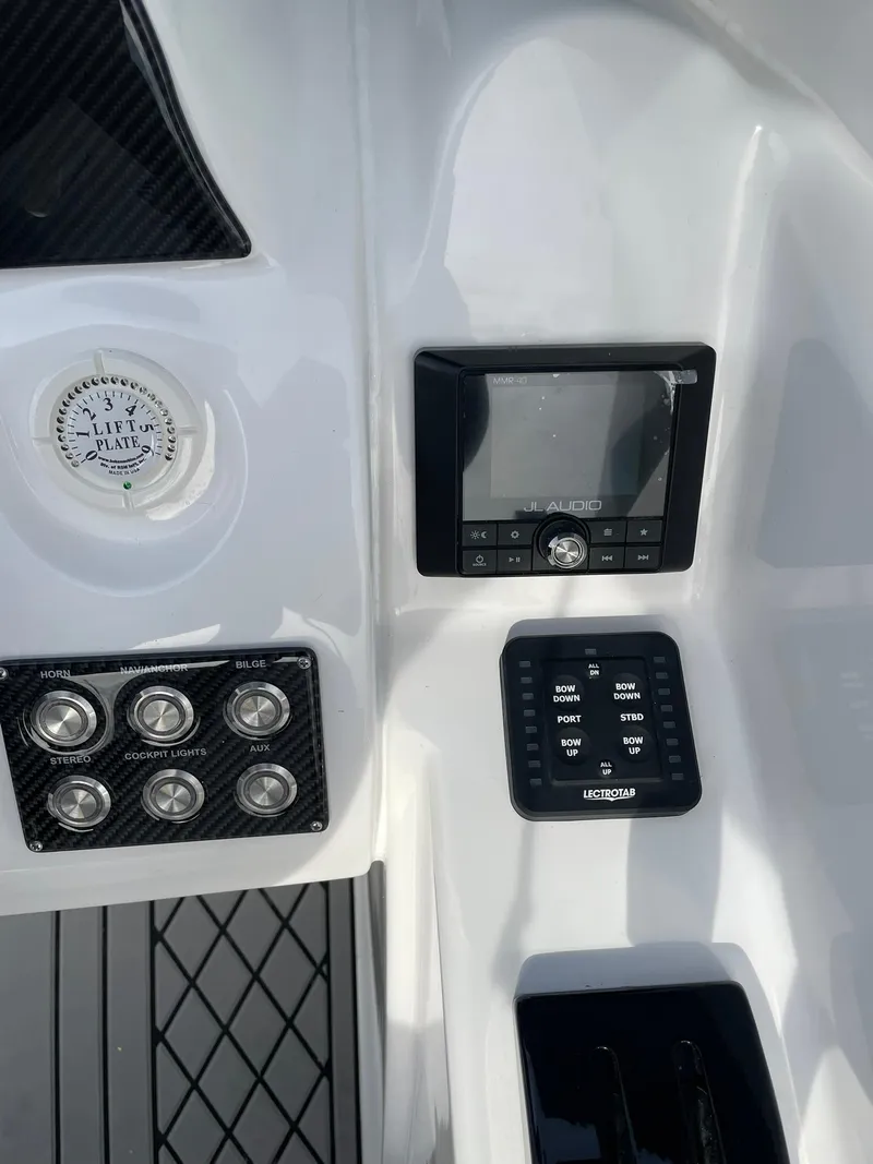 Slide: The Image of 2025 Checkmate Pulsare 2400 BRX boat dashboard with controls and gauges. - 13