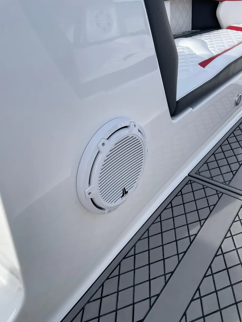Slide: The Image of 2025 Checkmate Pulsare 2400 BRX boat interior with speaker and cushioned seating. - 21