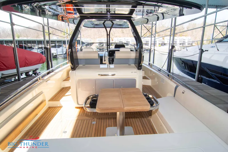 Slide: The Image of 2024 Invictus GT370S luxury boat interior with wooden deck and seating area. - 10