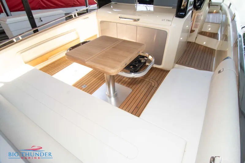 Slide: The Image of 2024 Invictus GT370S boat interior with wooden table and seating area. - 11
