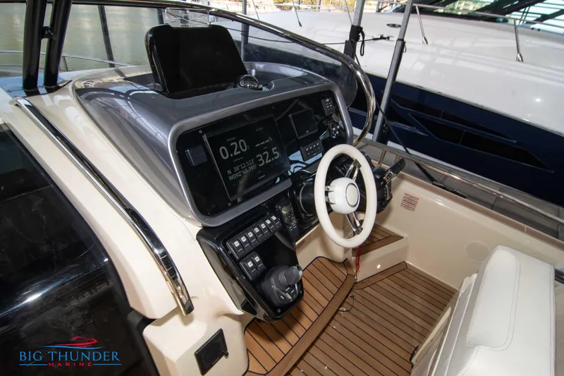Slide: The Image of 2024 Invictus GT370S boat cockpit with modern controls and wooden flooring. - 26