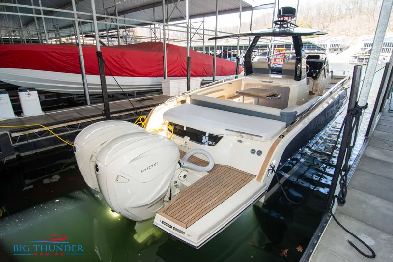 Slide: The Image of 2024 Invictus GT370S luxury motorboat docked at marina with twin outboard engines. - 3