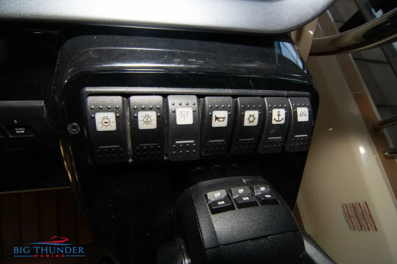 Slide: The Image of Control panel of 2024 Invictus GT370S boat with various function switches. - 33