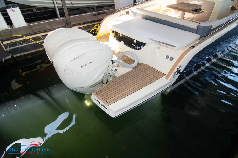 Slide: The Image of 2024 Invictus GT370S luxury boat with twin outboard engines docked. - 5