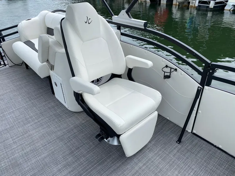 Slide: The Image of 2024 JC Neptoon Sport 23TT DSL boat with white captain's chair and lake view. - 9