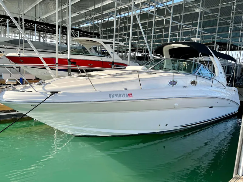 Slide: The Image of 2007 Sea Ray 320 Sundancer docked in marina, white exterior, calm water. - 2
