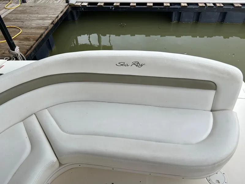 Slide: The Image of 2007 Sea Ray 320 Sundancer boat seating by dock, featuring white cushioned seats. - 22