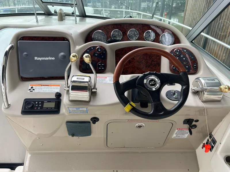 Slide: The Image of 2007 Sea Ray 320 Sundancer helm with Raymarine electronics and wood-accented steering wheel. - 24