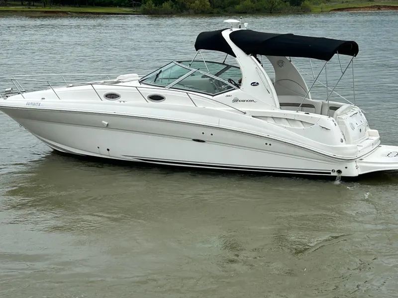 Slide: The Image of 2007 Sea Ray 320 Sundancer boat on calm water with black canopy. - 26