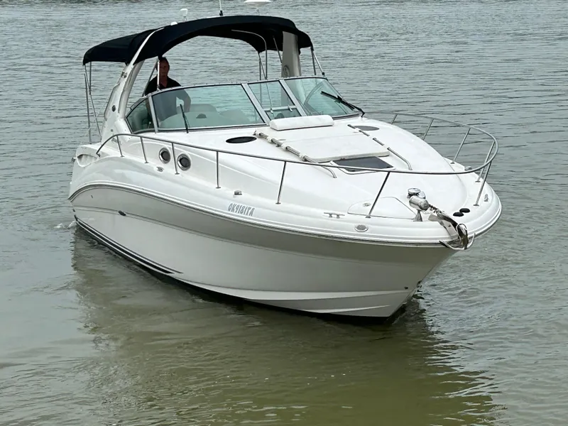 Slide: The Image of 2007 Sea Ray 320 Sundancer boat on calm water, featuring sleek design and black canopy. - 31