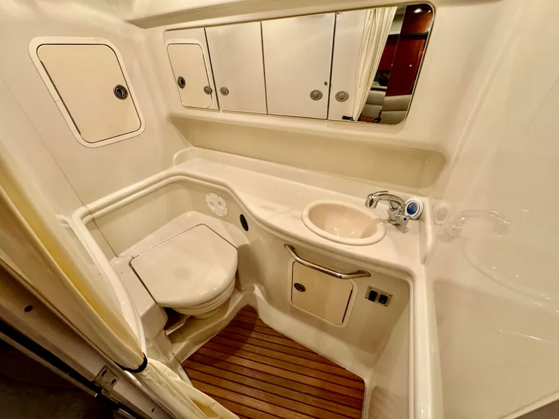 Slide: The Image of 2007 Sea Ray 320 Sundancer bathroom with sink, toilet, and storage cabinets. - 8