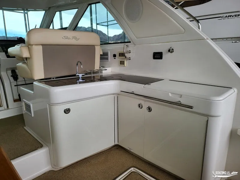 Slide: The Image of Interior of 2012 Sea Ray 450 Sundancer yacht with kitchenette and seating area. - 18