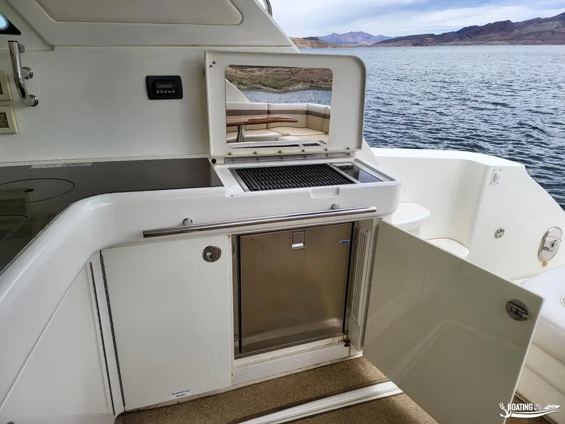 Slide: The Image of Outdoor kitchen on a 2012 Sea Ray 450 Sundancer yacht with a scenic lake view. - 21