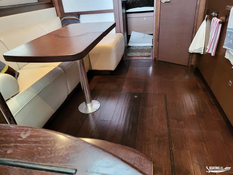 Slide: The Image of Interior of 2012 Sea Ray 450 Sundancer with wooden flooring and white seating. - 24