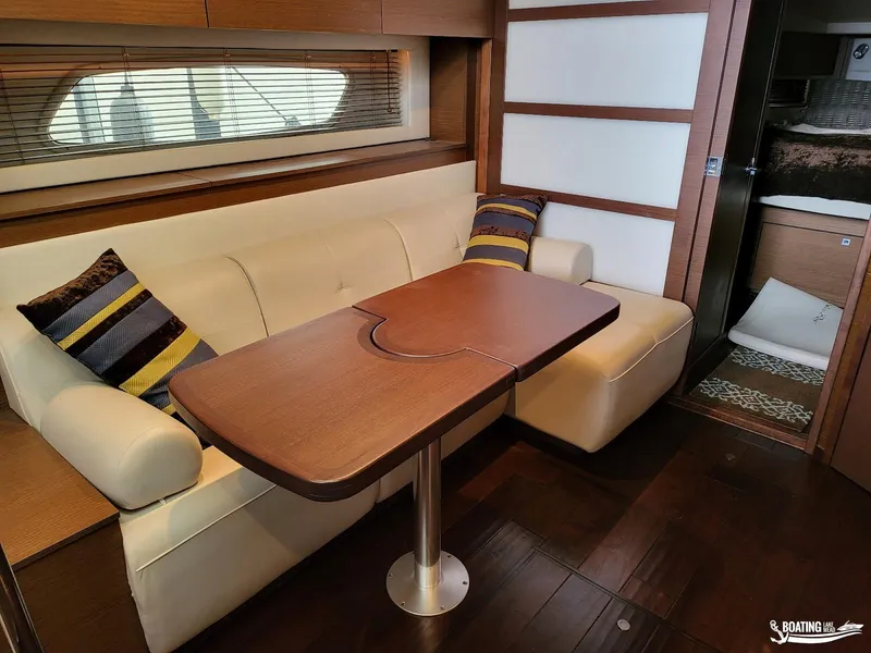 Slide: The Image of Interior of 2012 Sea Ray 450 Sundancer with dining area and wooden table. - 25