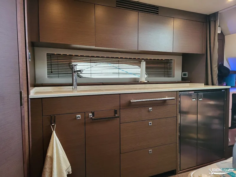 Slide: The Image of Modern kitchen area in a 2012 Sea Ray 450 Sundancer yacht with sleek cabinetry and stainless steel appliances. - 31