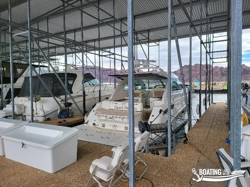 Slide: The Image of 2012 Sea Ray 450 Sundancer docked at marina with covered roof. - 36