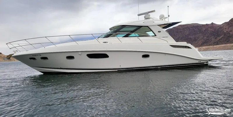 Slide: The Image of 2012 Sea Ray 450 Sundancer yacht on calm water with mountainous background. - 7